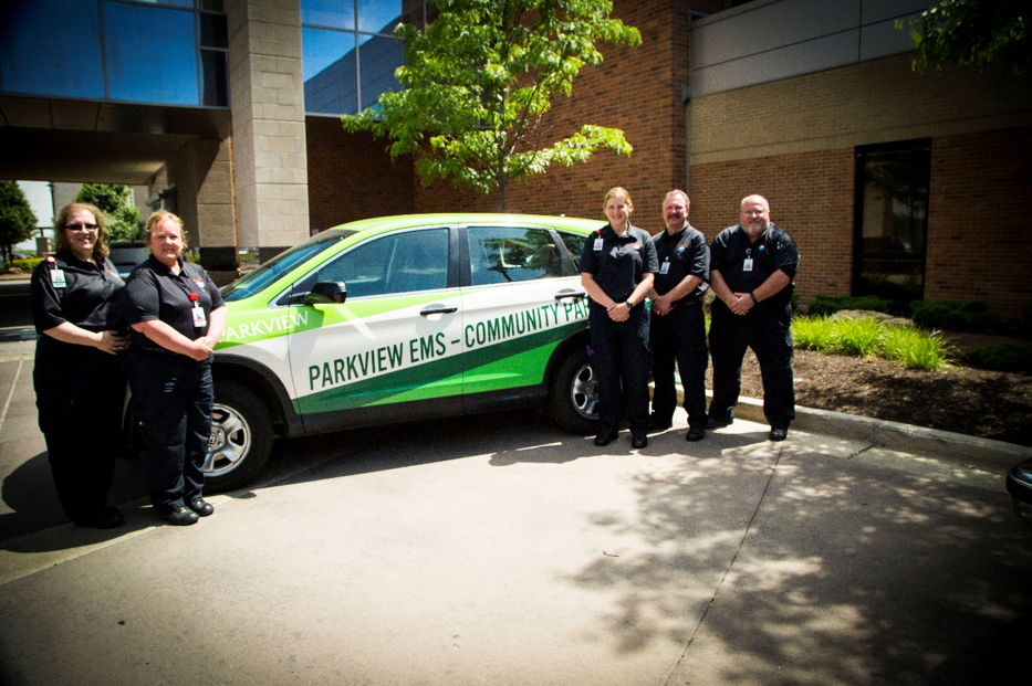 Paramedics posing around a car